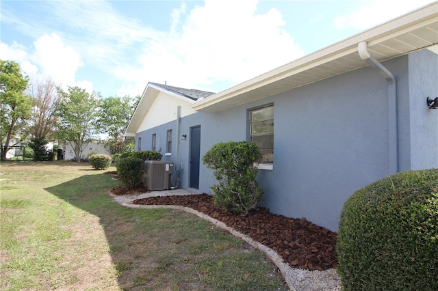 view of home's exterior featuring a lawn and central air condition unit