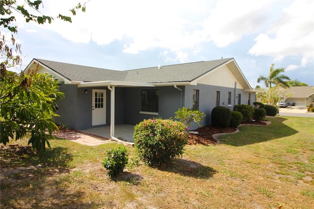 back of house featuring a lawn and a patio area