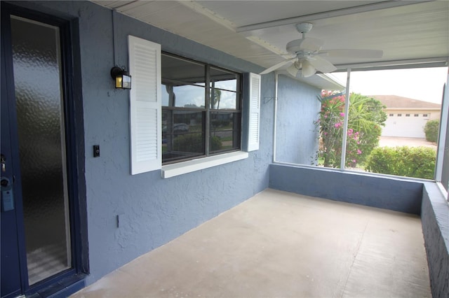 unfurnished sunroom with ceiling fan