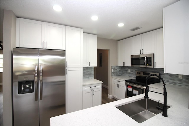 kitchen with tasteful backsplash, stainless steel appliances, and white cabinetry