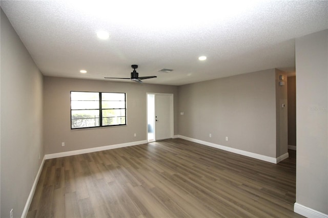 spare room with a textured ceiling, ceiling fan, and dark hardwood / wood-style flooring