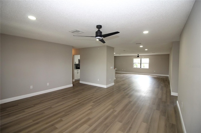 spare room with a textured ceiling, ceiling fan, and dark hardwood / wood-style floors