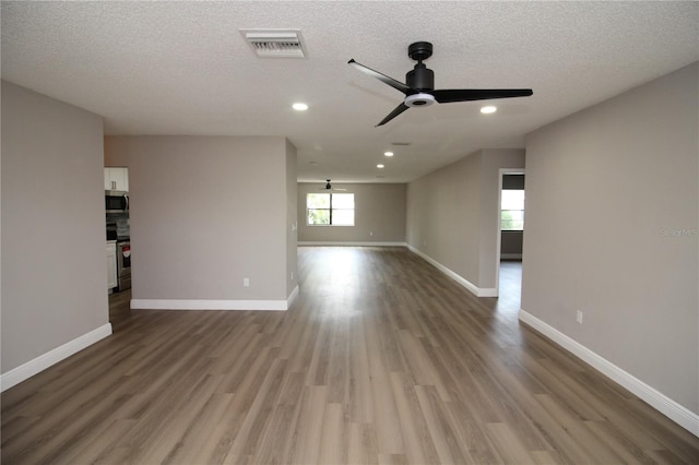 empty room with hardwood / wood-style floors, a textured ceiling, and ceiling fan