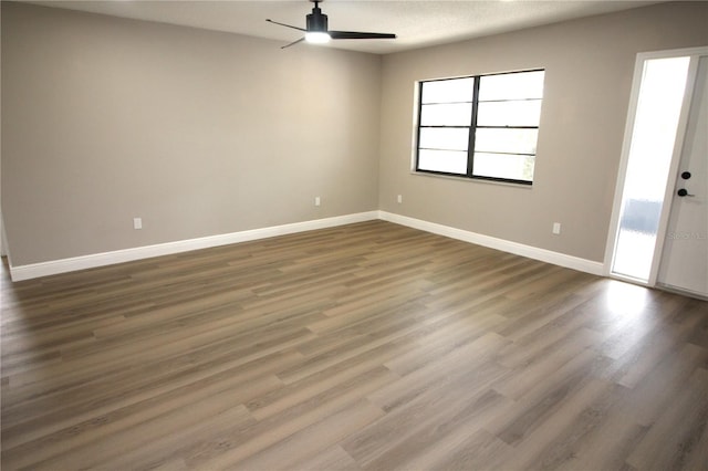 unfurnished room featuring dark hardwood / wood-style flooring and ceiling fan