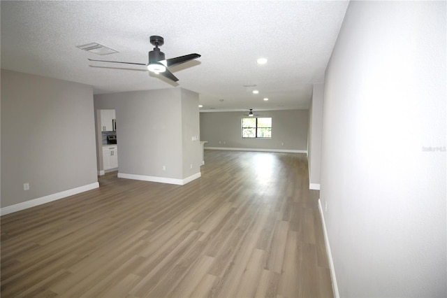 interior space featuring hardwood / wood-style floors, a textured ceiling, and ceiling fan