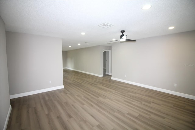 spare room with a textured ceiling, dark hardwood / wood-style floors, and ceiling fan