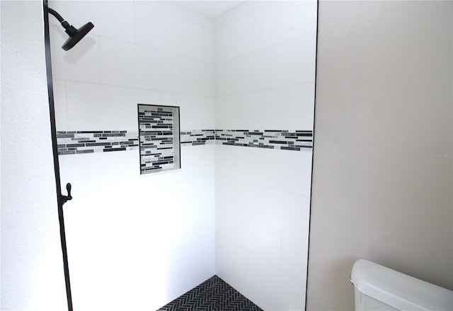 bathroom featuring toilet and tiled shower