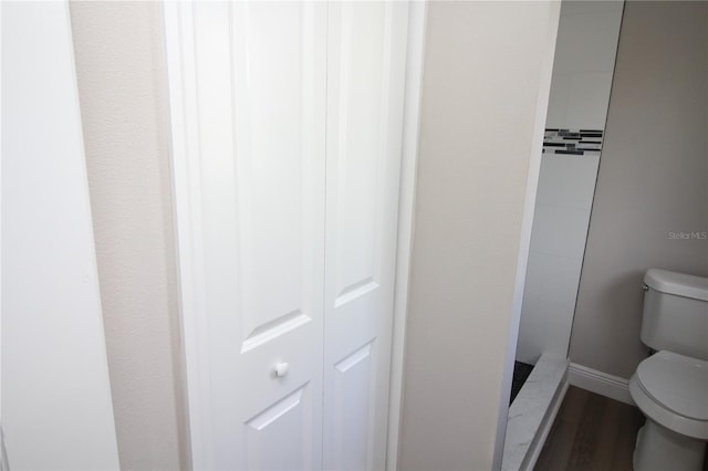 bathroom with toilet and wood-type flooring