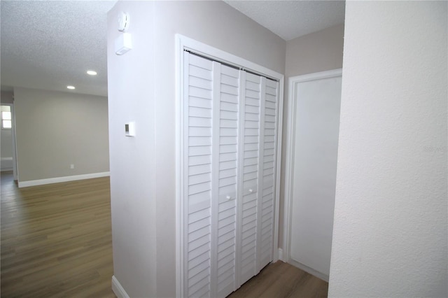 hall with dark hardwood / wood-style floors and a textured ceiling