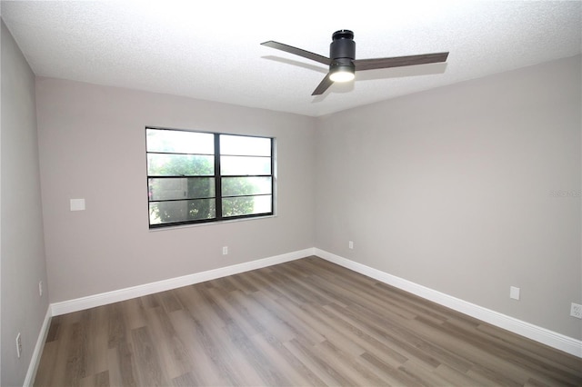 spare room with dark wood-type flooring, ceiling fan, and a textured ceiling