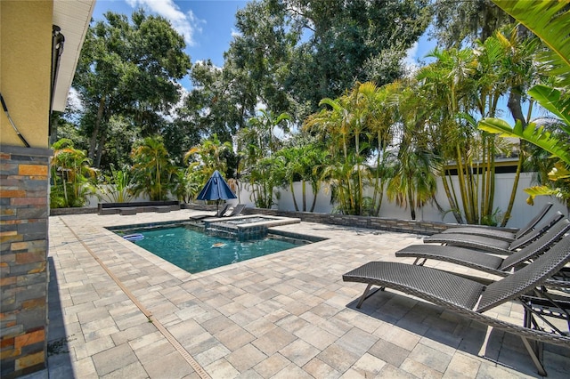 view of swimming pool featuring a patio and an in ground hot tub