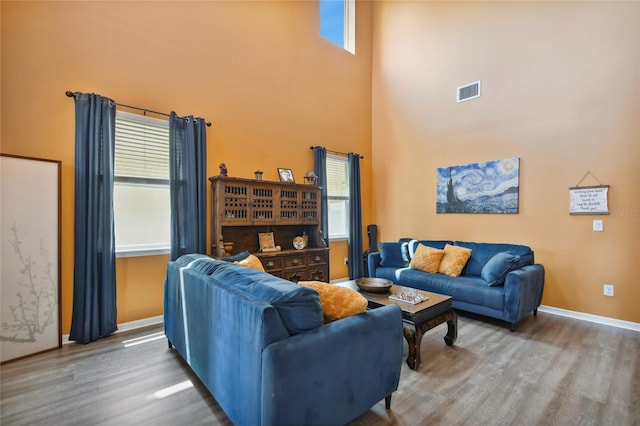 living room with a high ceiling and wood-type flooring