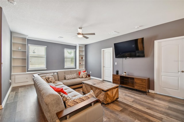 living room with built in features, a textured ceiling, ceiling fan, and dark hardwood / wood-style flooring