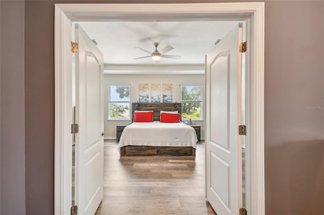 bedroom with dark hardwood / wood-style flooring and ceiling fan