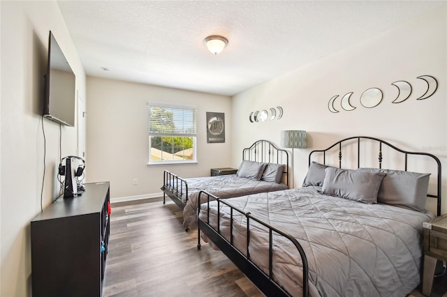 bedroom with dark hardwood / wood-style floors and a textured ceiling