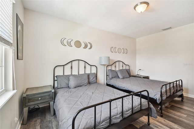 bedroom with multiple windows and hardwood / wood-style flooring