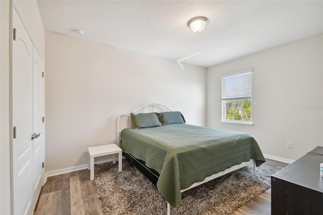 bedroom with dark hardwood / wood-style floors