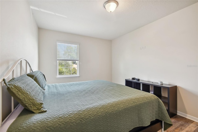 bedroom with dark hardwood / wood-style floors