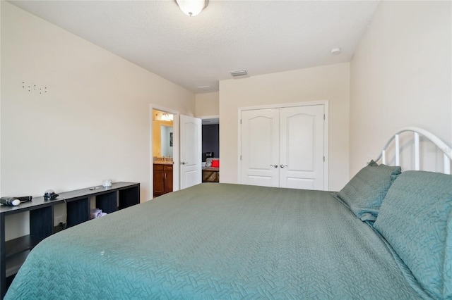 bedroom with ensuite bathroom and a closet