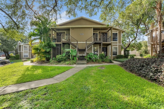 view of front of house with a balcony and a front yard