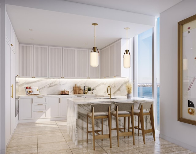 kitchen featuring pendant lighting, a kitchen bar, tasteful backsplash, white cabinets, and sink
