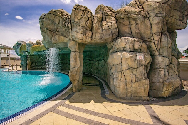 view of pool with a patio area and pool water feature