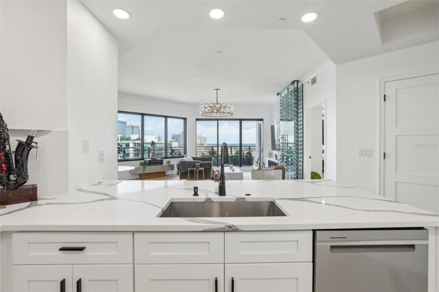 kitchen with dishwasher, sink, light stone countertops, and white cabinets