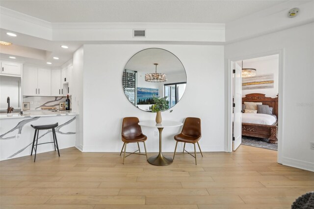 interior space featuring light hardwood / wood-style flooring, an inviting chandelier, and sink