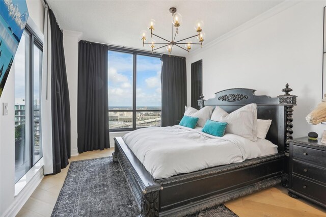 bedroom featuring crown molding, an inviting chandelier, and light hardwood / wood-style flooring