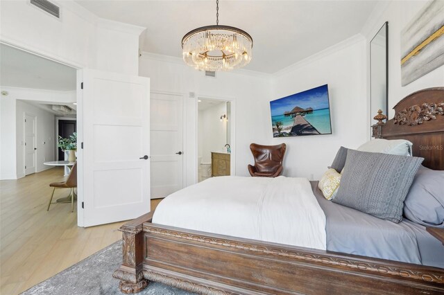 bedroom featuring crown molding, an inviting chandelier, and light hardwood / wood-style floors