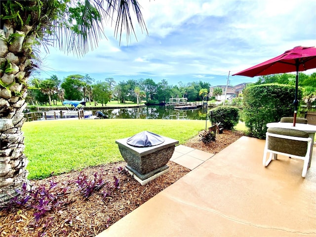 view of yard featuring a water view, a patio area, and a fire pit