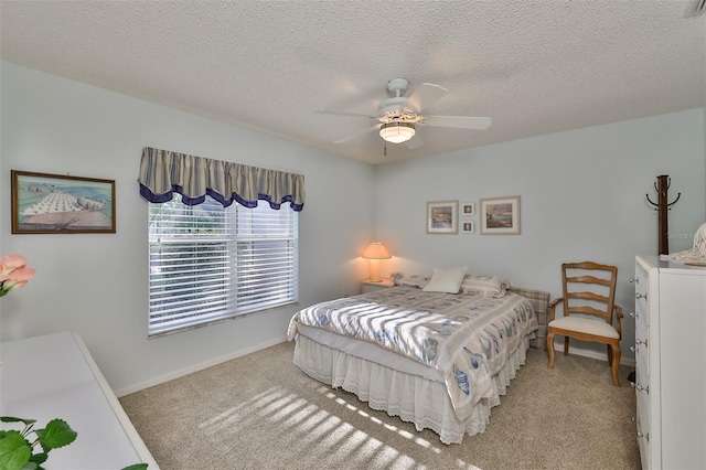 carpeted bedroom featuring a textured ceiling and ceiling fan