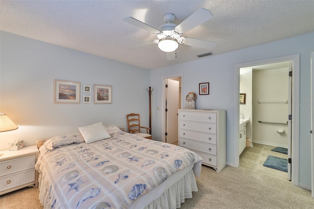 bedroom with light tile floors, a textured ceiling, ceiling fan, and ensuite bathroom