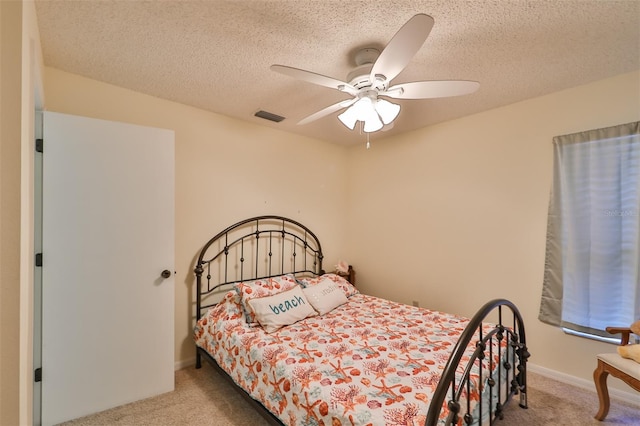 carpeted bedroom featuring ceiling fan and a textured ceiling