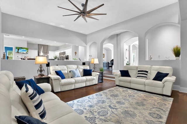 living room featuring ceiling fan and dark hardwood / wood-style flooring