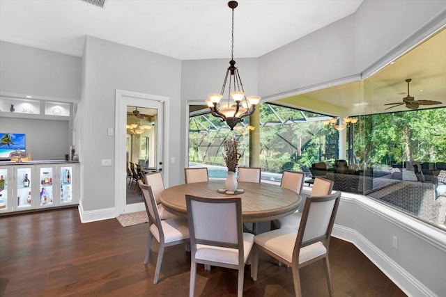 dining space featuring dark hardwood / wood-style flooring and ceiling fan with notable chandelier