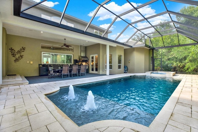 view of swimming pool featuring pool water feature, a lanai, an in ground hot tub, ceiling fan, and a patio