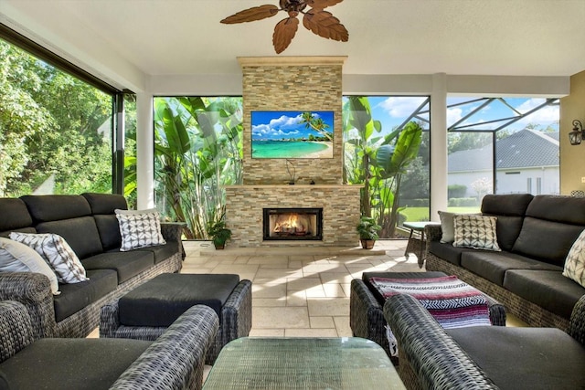 sunroom / solarium featuring ceiling fan and an outdoor stone fireplace