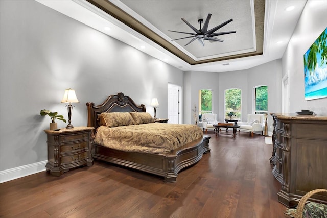 bedroom with dark wood-type flooring and a tray ceiling