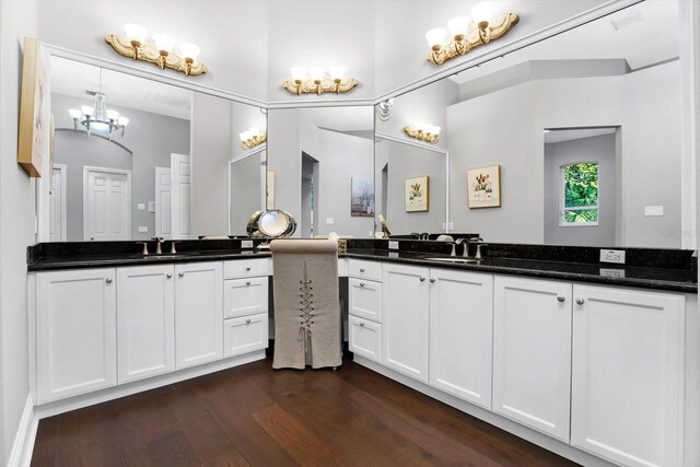 bathroom with hardwood / wood-style flooring, vanity, and an inviting chandelier