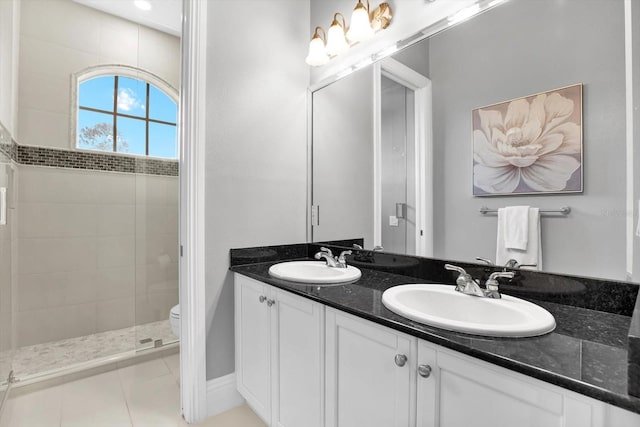 bathroom with vanity, a tile shower, tile patterned floors, and toilet