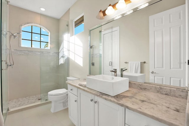 bathroom featuring vanity, a shower with shower door, and toilet