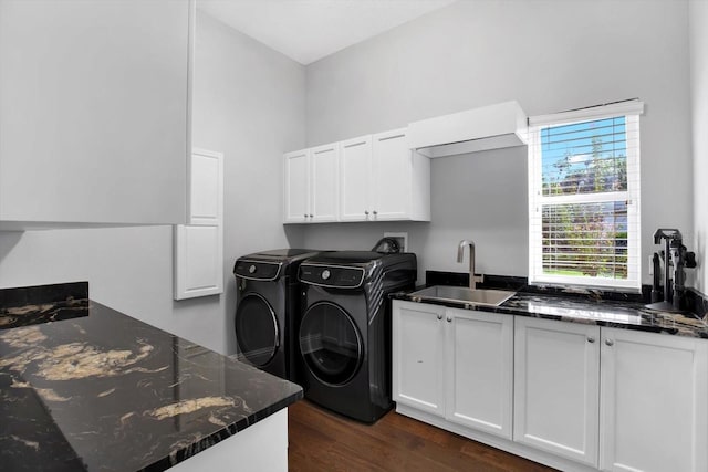 laundry area featuring cabinets, washing machine and clothes dryer, dark hardwood / wood-style floors, and sink