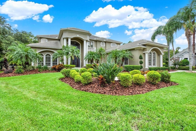 mediterranean / spanish home with a front yard and french doors