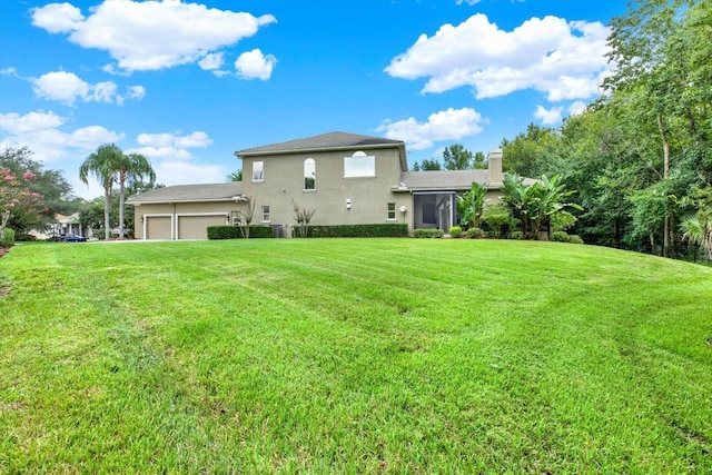 rear view of house featuring a garage and a yard