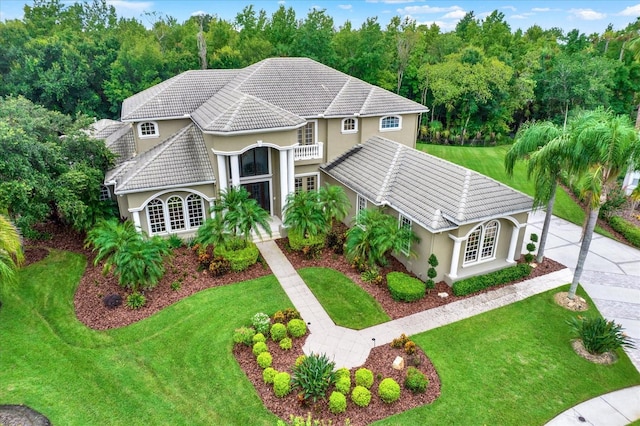 view of front of property featuring a front yard and a balcony