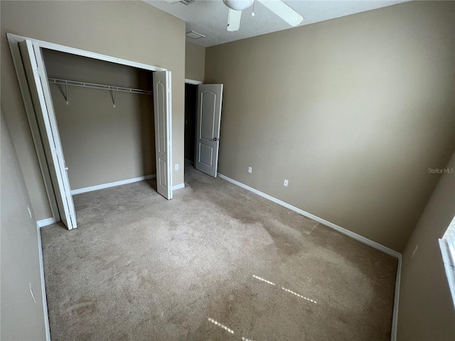 unfurnished bedroom featuring ceiling fan, a closet, and light carpet