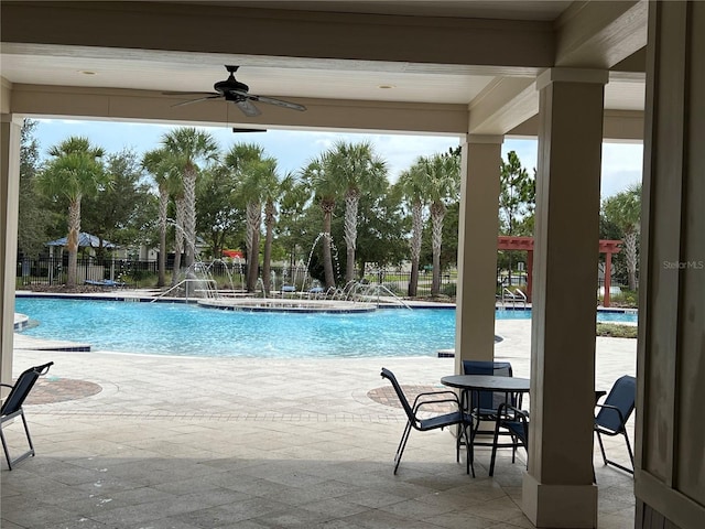 view of swimming pool with ceiling fan, pool water feature, and a patio