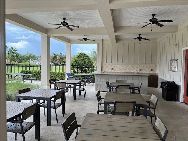 view of patio featuring ceiling fan and a bar