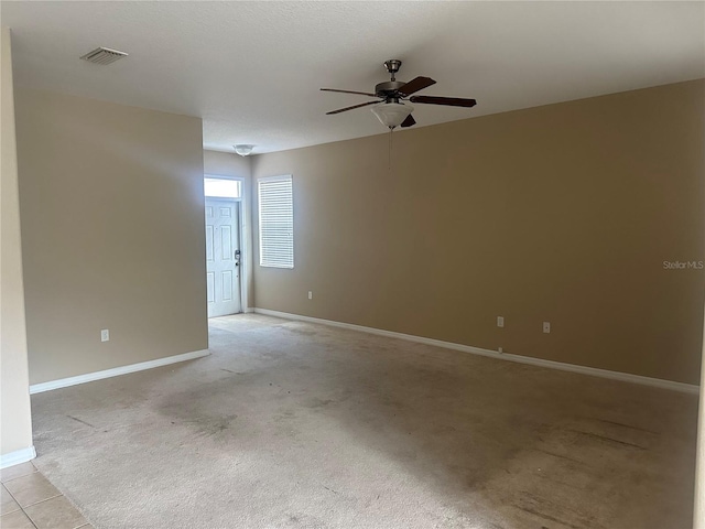 spare room with ceiling fan and light carpet